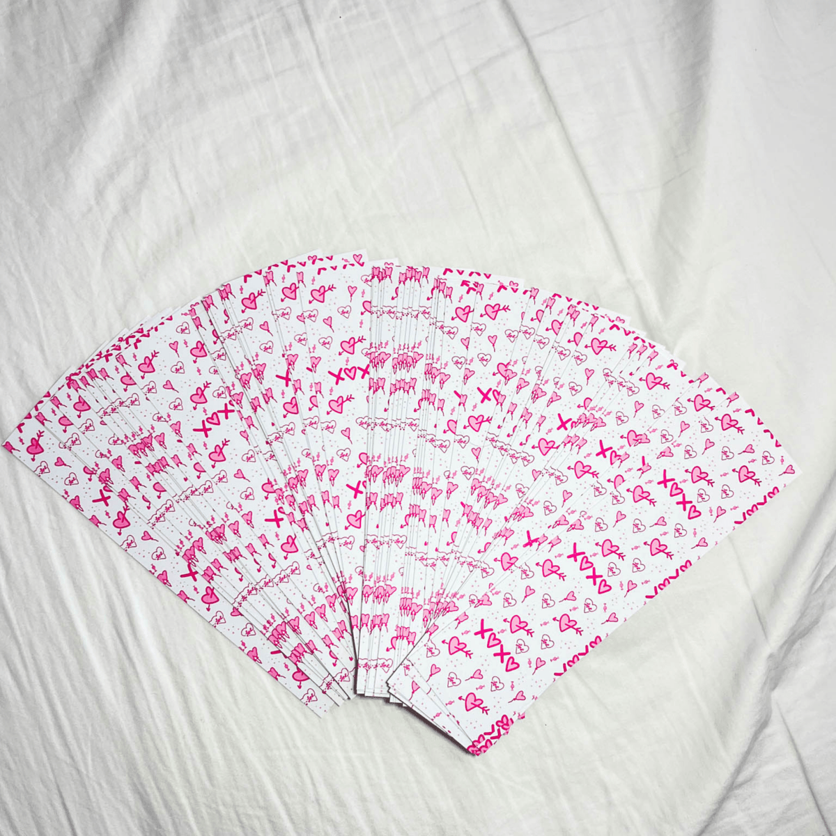 Rectangle bookmarks containing a pink heart pattern design fanned out against a white background