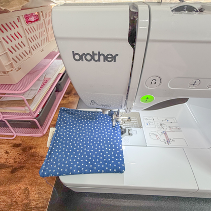 Brother sewing machine with blue fabric on a wooden table
