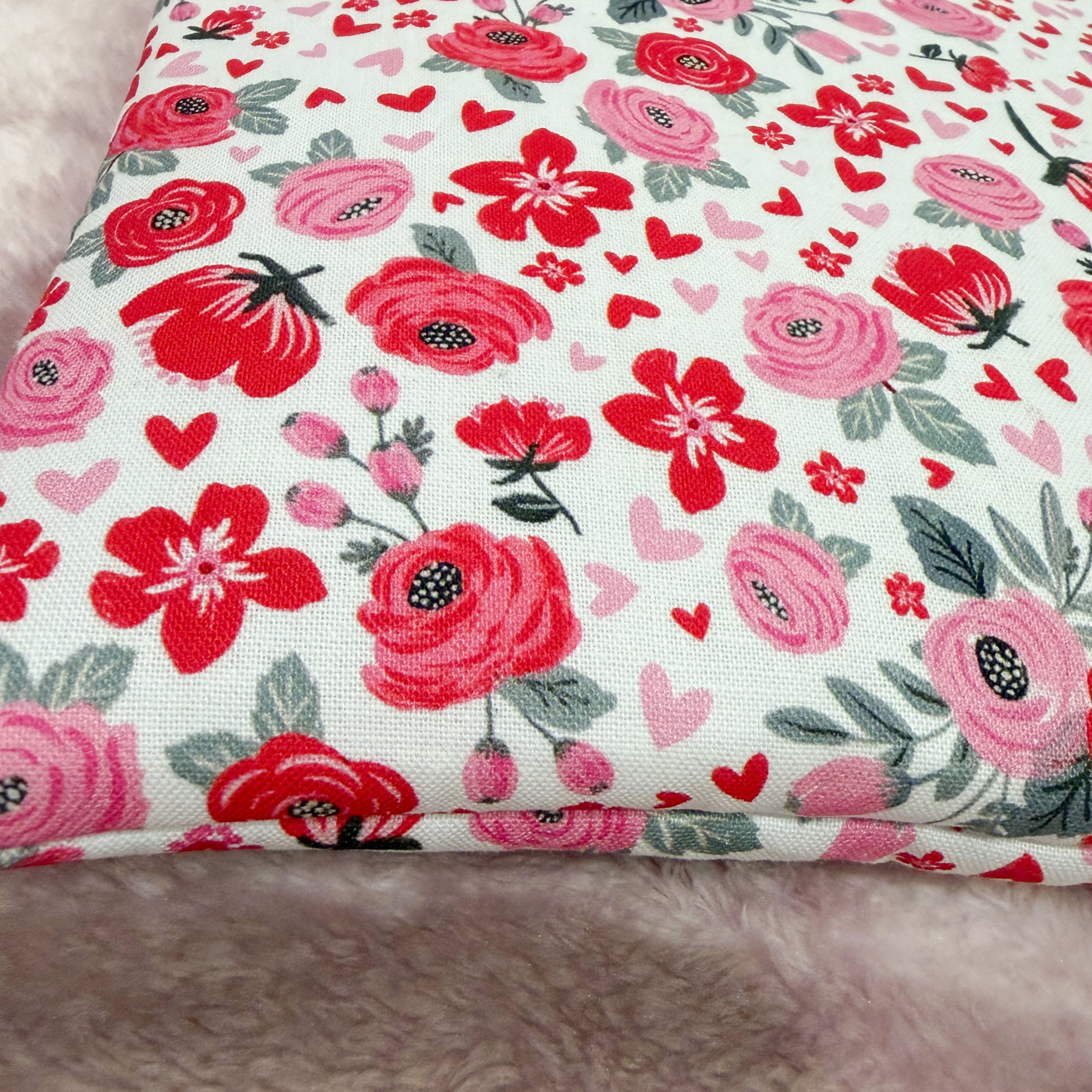 Floral fabric with red and pink flowers and hearts on a white background