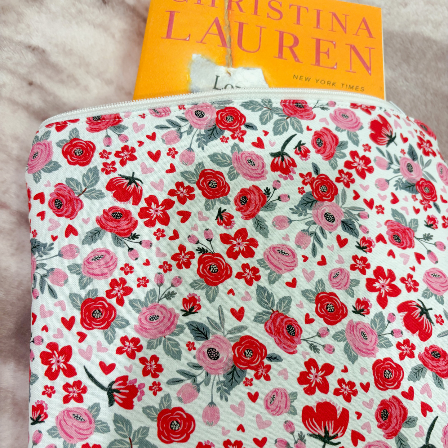 Floral-patterned book sleeve with a book titled 'Christina Lauren' on a light background