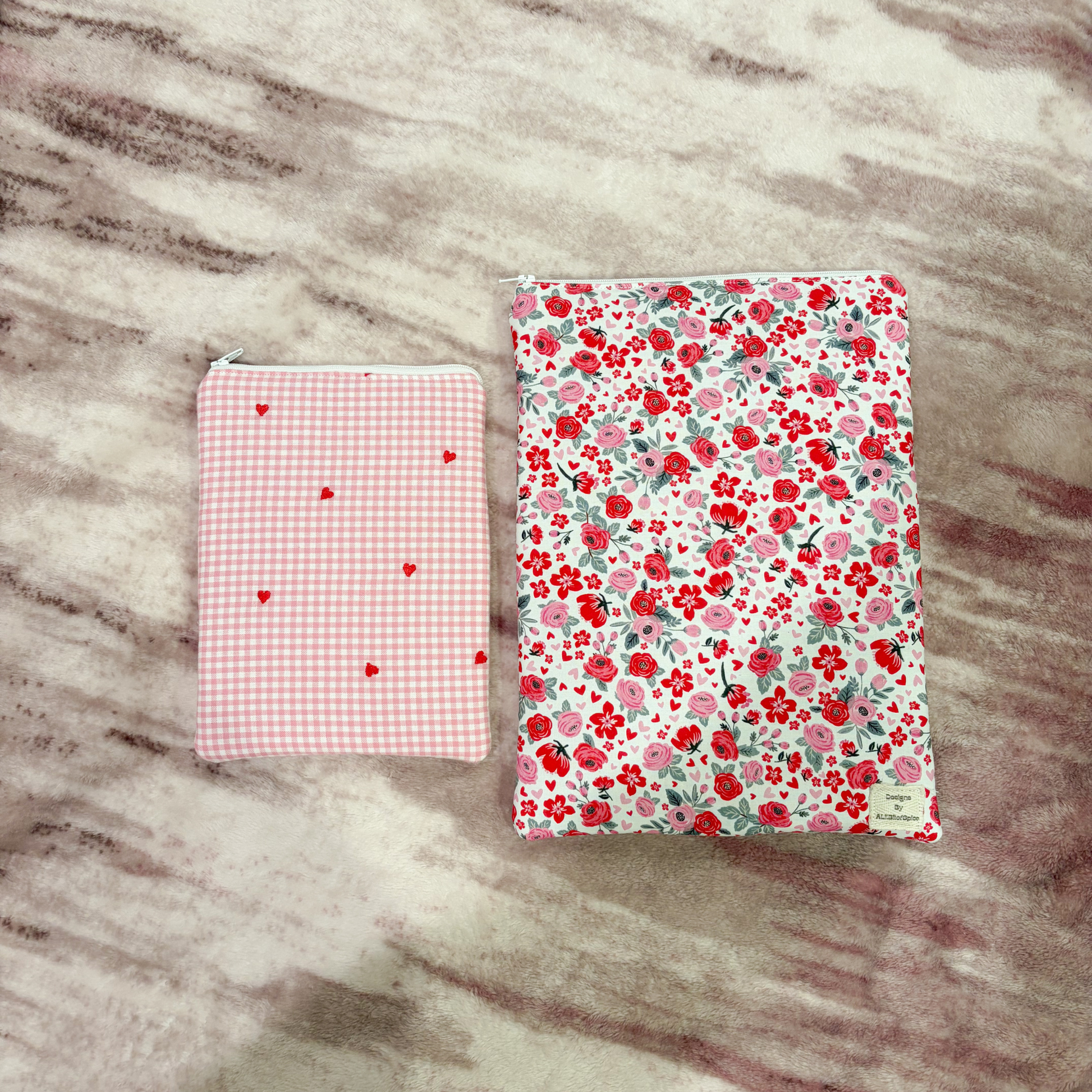Two book sleeves of different sizes with different patterns on a marble surface