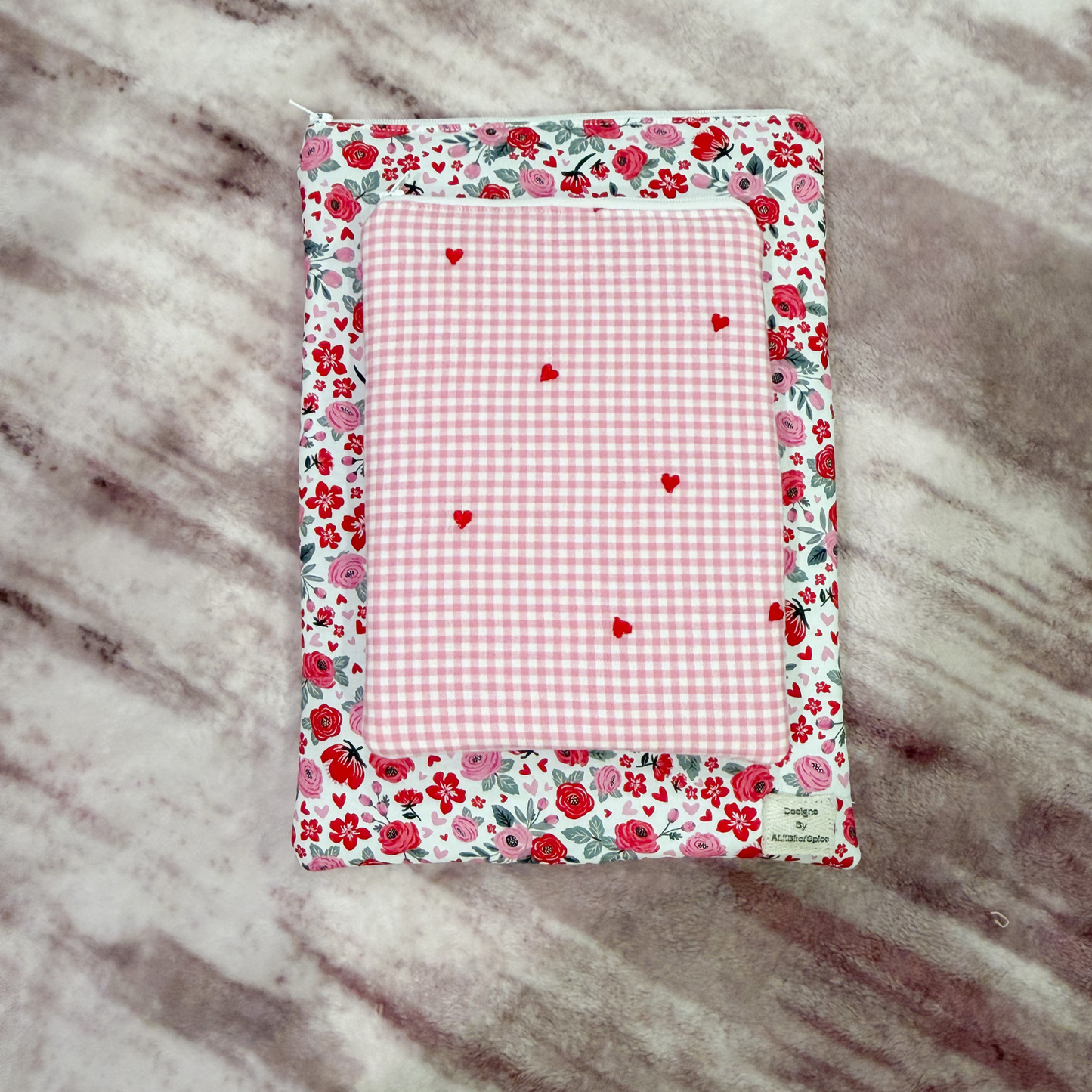 Floral and checkered book sleeves stacked on one another on a marble surface