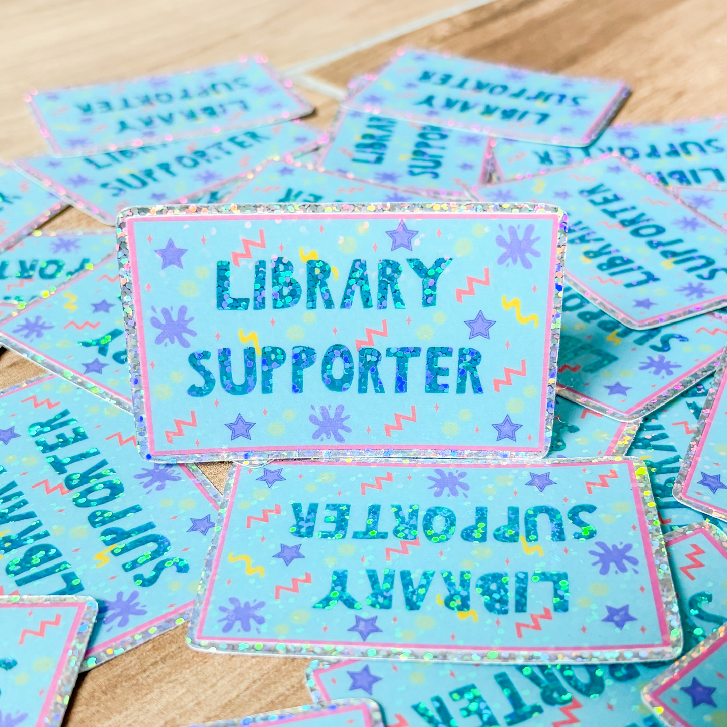 Stickers with 'Library Supporter' text on a wooden surface